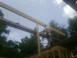 Carpenter setting a ridge beam over a new addition frame — Ice Dam Removal by Roofing Brothers in North Windham