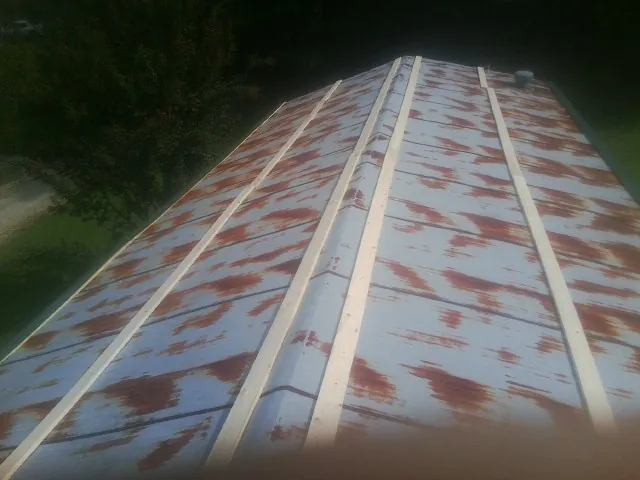 Rusted metal roof panels with new wood purlins before replacement — Storm Damage Roof Repair in North Windham by Roofing Brothers