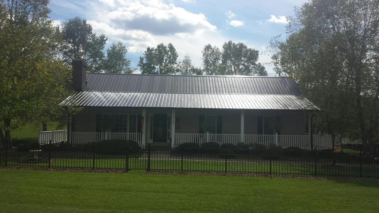 Gray metal roof on a brick ranch with a full width front porch — Gutter Guard Installation work by our crew in North Windham
