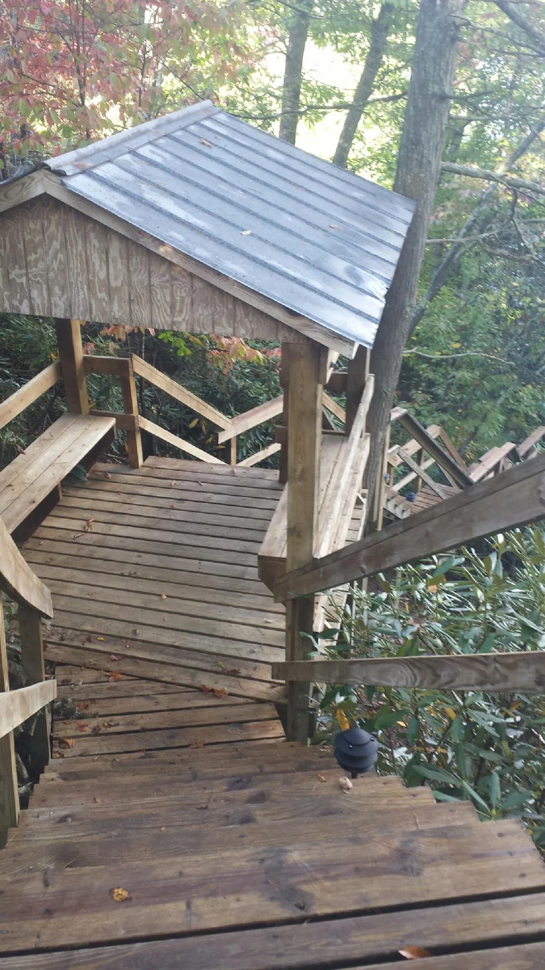 Metal roofed shelter over wooden steps on a wooded walkway — Skylight Repair & Installation work by our crew in North Windham