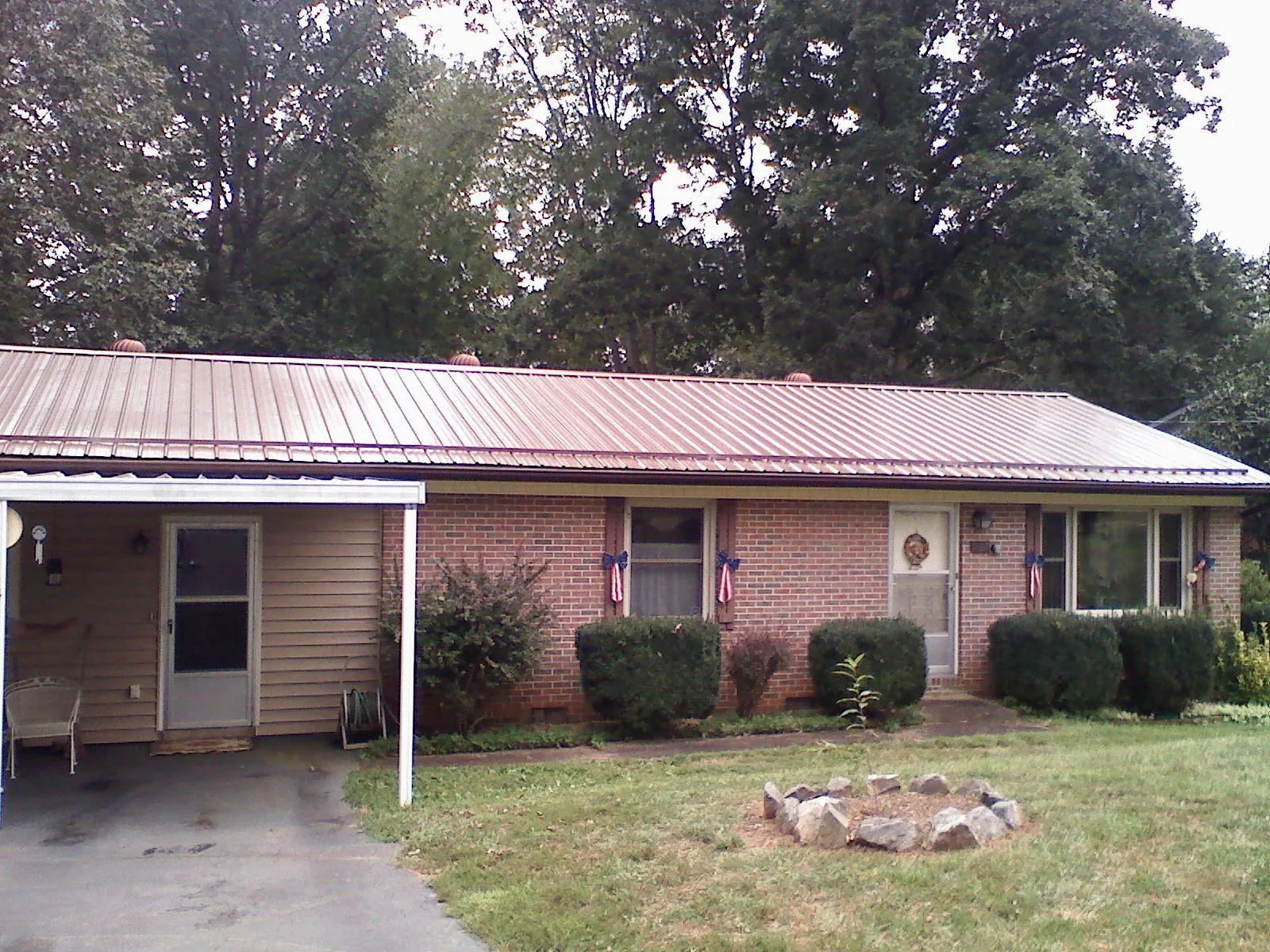 Bronze metal roof and carport on a brick ranch home — Roof Repair work by our crew in North Windham